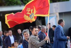 epa05321914 A man holds the Montenegrin flag at the Independence Square during the celebrations for the country's 10th anniversary of its Independence Day in Podgorica, Montenegro, 21 May 2016. EPA/BORIS PEJOVIC